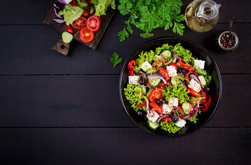 Healthy food. Greek salad with cucumber, tomato, sweet pepper, lettuce, red onion, feta cheese and...