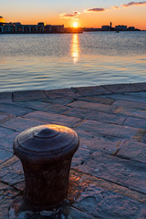 Naklejka premium Sunset from the Audace pier of Trieste. Colors of fire on the water. Italy