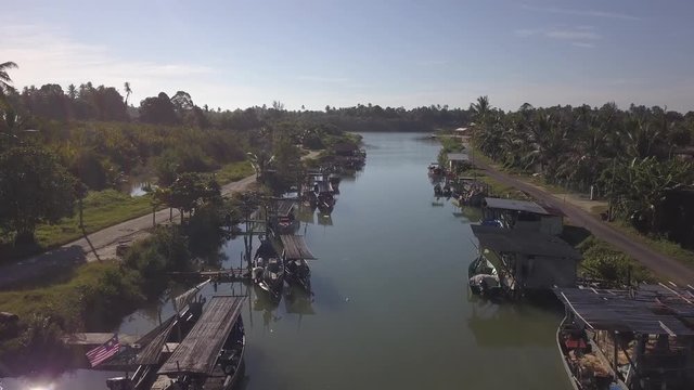 Aerial view of fisherman village with boats dock at the river estuary nearby.