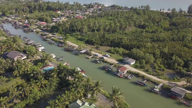 Aerial view of fisherman village with boats dock at the river estuary nearby.