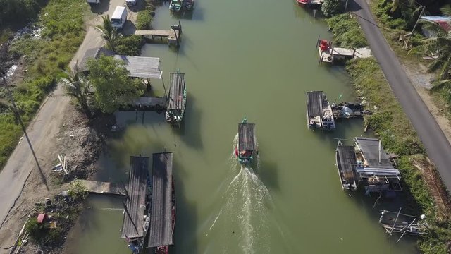 Aerial view of fisherman village with boats dock at the river estuary nearby.