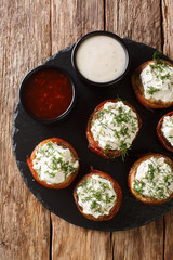 mushrooms wrapped in bacon and stuffed with cream cheese with greens closeup on a plate. Vertical top view