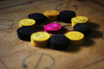A game of carom set and ready to play.A game of carrom with pieces carrom man on the board...