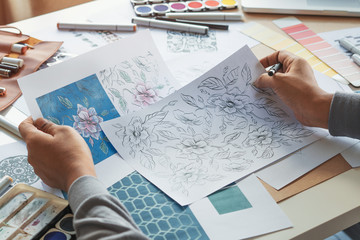 Designer designing drawing sketch pattern geometric flower seamless wallpaper fabric textile fashion industry. artistic design studio.. © Chaosamran_Studio