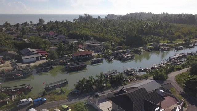Aerial view of fisherman village with boats dock at the river estuary nearby.