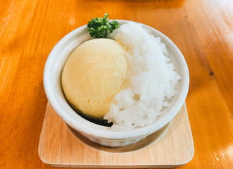 Mango ice cream home made and sticky rice in ceramic cup on the wood table.