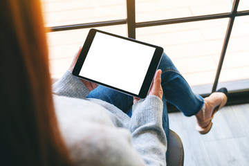 Mockup image of a woman holding black tablet pc with blank white screen