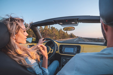 The young couple traveling by a cabriolet