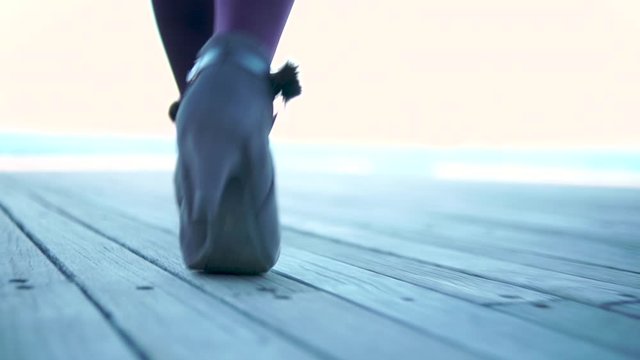 ブーツでウッドデッキを歩く女性