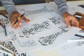 Typography Calligraphy artist designer drawing sketch writes letting spelled pen brush ink paper...