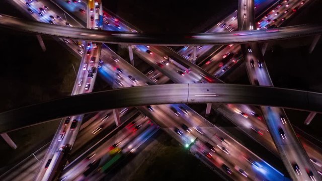 Top down aerial view drone shot from above New York City modern urban freeway network, interstate and highway at night with heavy traffic.