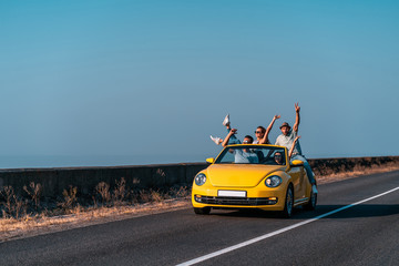 The friends travel by a cabriolet