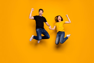 Fototapeta na wymiar Oh yeah. Full body photo of crazy guy lady couple jumping high celebrating first win place competition triumphing wear casual jeans black t-shirts isolated yellow color background