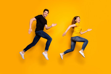Fototapeta na wymiar Full body photo of cool guy lady couple jumping high active way of life jogging every morning prepare pair race wear casual jeans black t-shirts isolated yellow color background