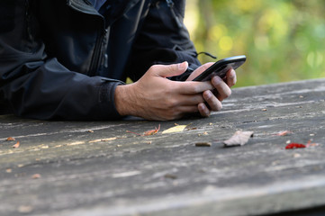 A man looking at a smartphone in the park