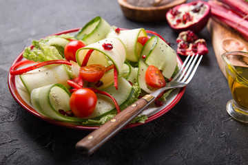 Healthy vegan diet salad with fresh vegetables -zucchini ,cucumber Beijing cabbage, tomato, chard and pomegranate seeds.Vegan food concept.