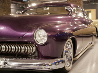The hood, headlight and front wheel of the vintage car are purple. Chrome grille and bumper....