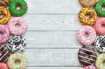 Background with colorful sweet cakes. Donuts with a hole with different toppings and decorations.