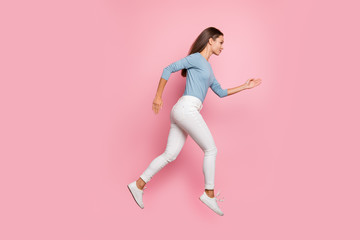 Fototapeta na wymiar Full length body size side profie photo of focused confident girl running jumping to her aim isolated pastel color background