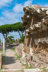 narrow dirt road with the remains of ancient houses and sculptures in the Italian antique city of...