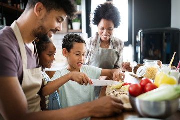 Happy family in the kitchen having fun and cooking together. Healthy food at home.