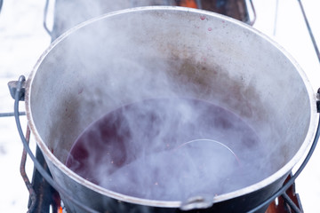 On a fire in a pot preparing mulled wine. Hot red wine on an open fire in winter.