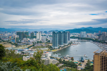 Fototapeta na wymiar Top View of Hainan's Sanya City, with local houses and luxury hotels and buildings. Summer Vacation Paradise in Asia.