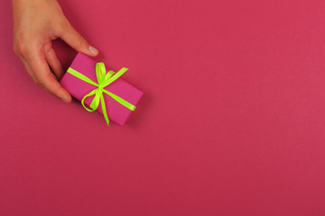 gift in female hands on a colored background top view. - Image