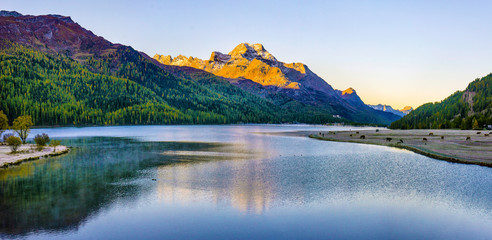 Mountain lake panorama with mountains reflection. Idyllic look. Autumn forest. Silvaplana Lake, Switzerland