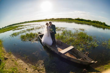 Fototapeta na wymiar Bride and groom on a wedding walk.Bride and groom in a boat against the sky