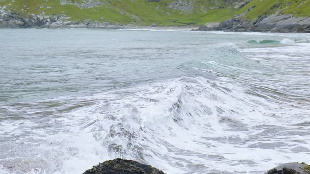 waves on the beach among the mountains in norway lofoten