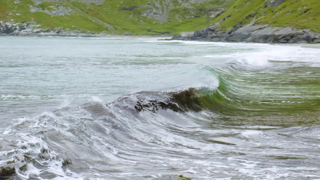 waves on the beach among the mountains in norway lofoten
