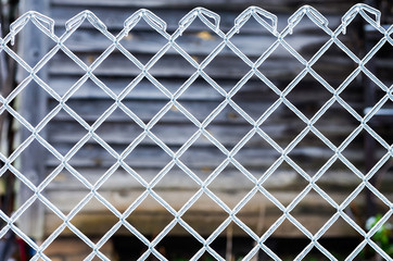 Fototapeta premium Ice on a fence made of metal mesh. Icy rain in the winter. Atmospheric phenomena of nature.