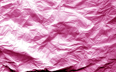 Crumpled sheet of paper with blur effect in pink tone.