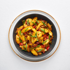 Baby Corn Manchurian dry looks like Schezwan Baby Corn isolated at white background. Baby Corn Manchurian - is indo chinese cuisine dish with deep fried corn, bell peppers, sauce and onion.