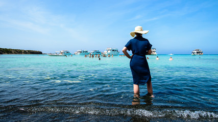 attractive woman on a sea cruise stands and looks at the sea