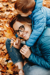 Portrait of a lovely young mother looking at camera laughing while playing with her little son...