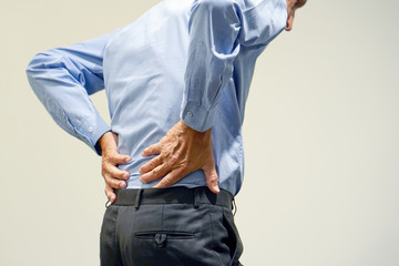 Closeup elderly man with pain in kidneys isolated on a gray background. Old man with back ache...