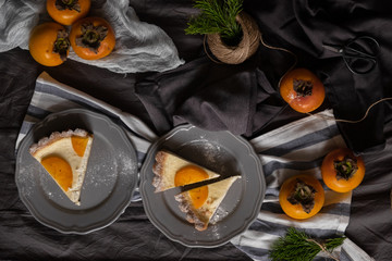 slices of persimmon cheesecake on beautiful plates. dark background. 