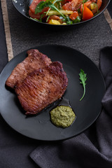 medium beef steaks with pesto sauce and vegetable salad. 