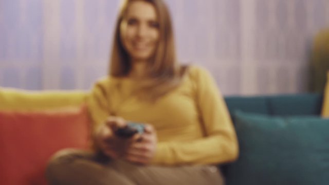 Smiling woman holding a remote control