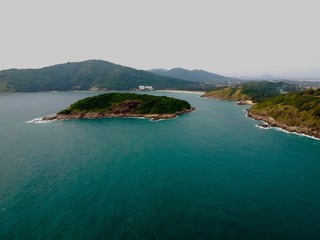 Obraz premium Wind turbine Panorama drone aerial view electricity windmill overlooking Naiharn beach phuket Thailand turquoise blue waters white golden sandy beach lush green mountains 
