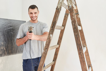 Young man as a handyman with power drill