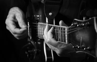 Crédence de cuisine en verre imprimé Noir et blanc Les mains du guitariste et la guitare se bouchent. jouer de la guitare électrique en noir et blanc.