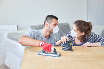 Young couple with multi-sander and respirator