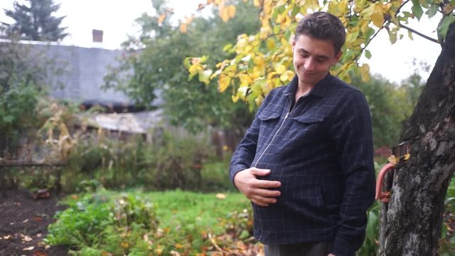 Pregnant man. The man tucked the pumpkin under his shirt