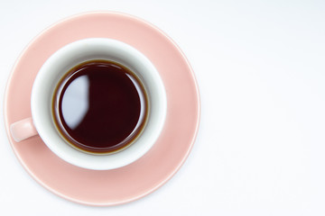 Black coffee in a coffee coral color cup isolated on a white background. Top view