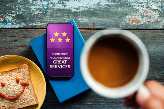 Customer Experiences Concept. Happy Client Giving Five Star Rating and Positive Review on Smartphone at Cafe or Restaurant. Food Blogger. Top View
