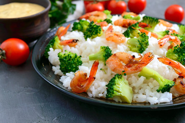Rice with broccoli, shrimps and cream cheese sauce. Healthy and tasty food. Proper nutrition. Sports diet.