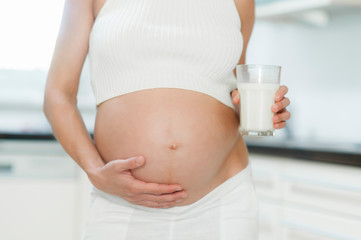 Schwangere Frau trinkt ein Glas Milch